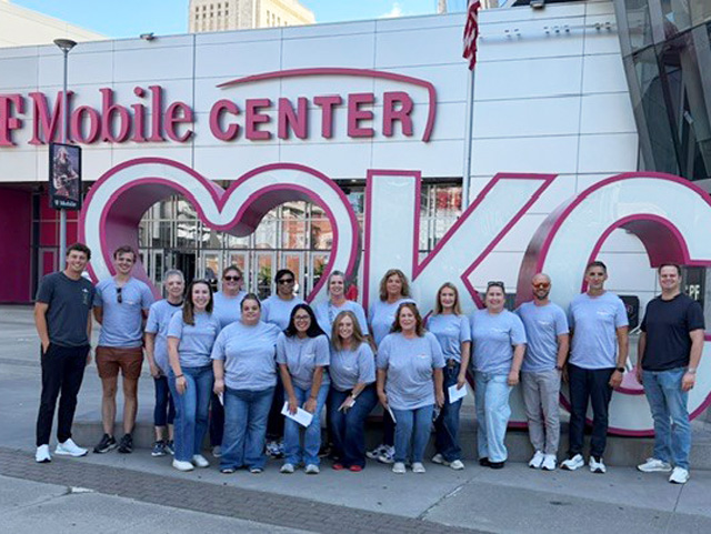A group of adults outside of the T-Mobile Center in Kansas City.