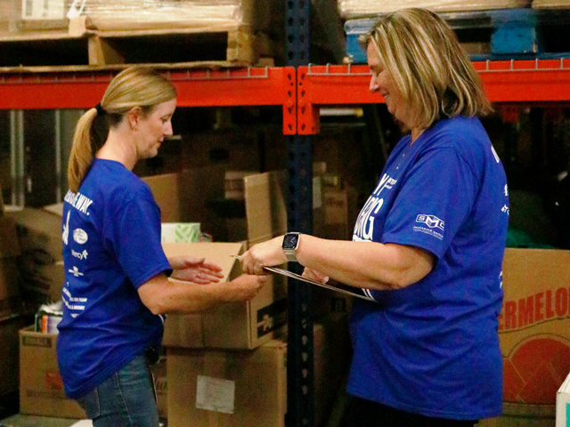 Two adults organizing at a food bank.